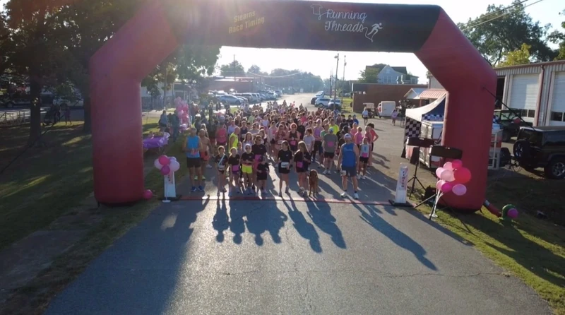 Participants gathered beneath the race arch at a community event